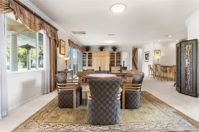 dining space with light colored carpet and ornamental molding