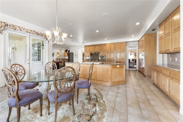 dining space with light tile patterned flooring, crown molding, and a chandelier