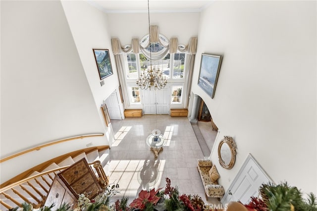 interior space featuring a high ceiling, an inviting chandelier, and ornamental molding