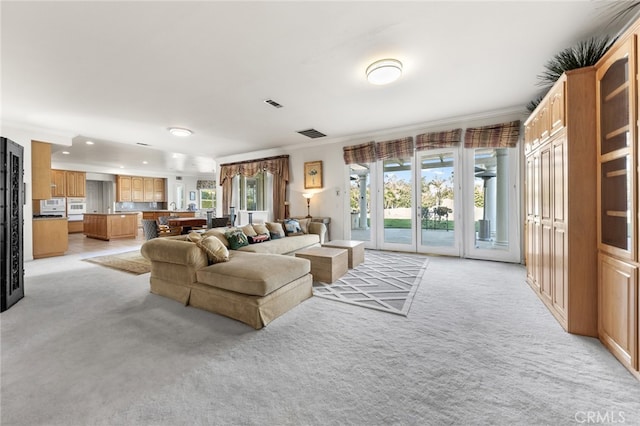 carpeted living room with ornamental molding