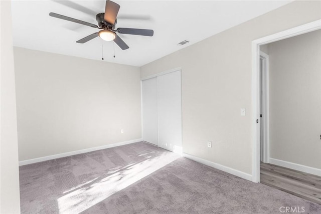 empty room featuring ceiling fan and light carpet