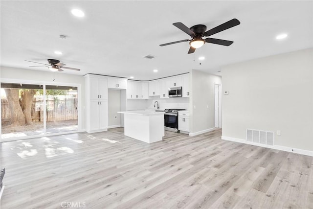 kitchen featuring white cabinetry, a kitchen island, light hardwood / wood-style floors, and appliances with stainless steel finishes