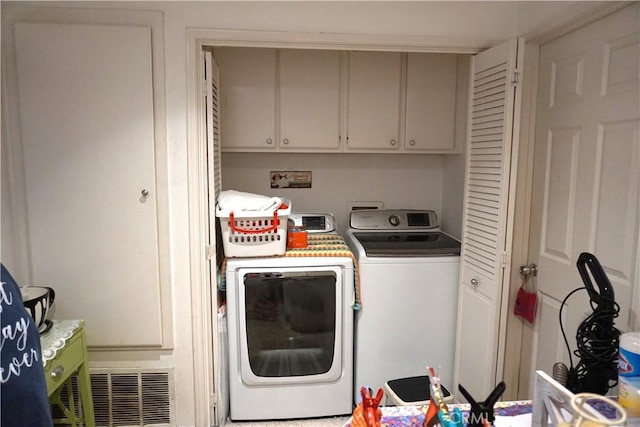 washroom featuring cabinets and independent washer and dryer