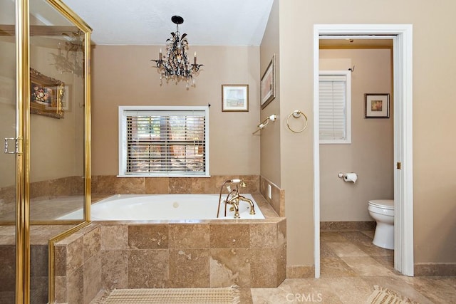 bathroom with tile patterned flooring, a relaxing tiled tub, toilet, and a notable chandelier