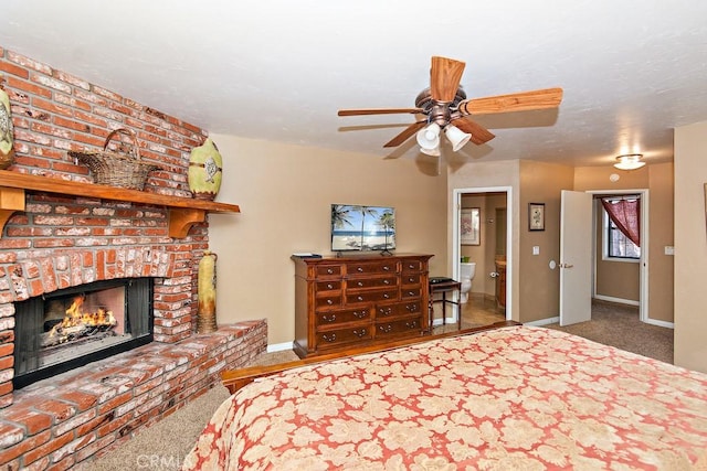 unfurnished bedroom with connected bathroom, ceiling fan, carpet, and a brick fireplace