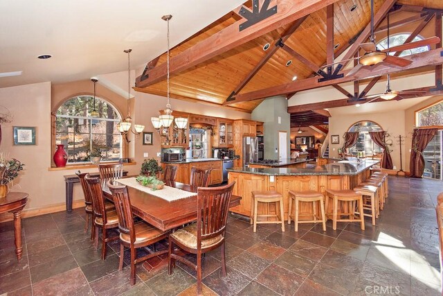 dining room featuring beamed ceiling, wooden ceiling, ceiling fan with notable chandelier, and high vaulted ceiling