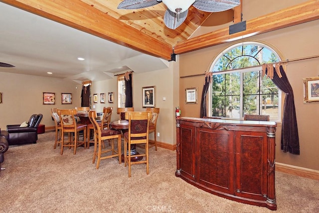 dining space with vaulted ceiling with beams and light colored carpet