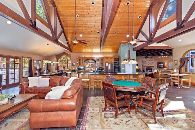 interior space with beamed ceiling, high vaulted ceiling, ceiling fan, and a wealth of natural light