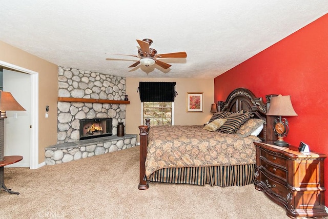 bedroom featuring carpet flooring, ceiling fan, a fireplace, and a textured ceiling