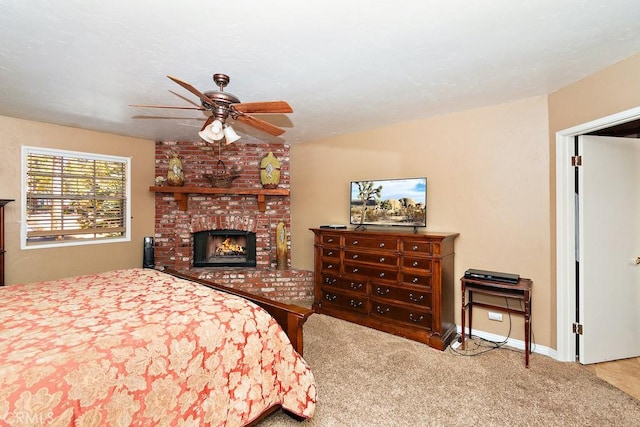 bedroom featuring ceiling fan, carpet, and a brick fireplace