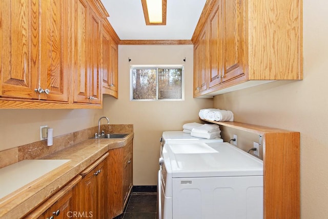 clothes washing area featuring dark tile patterned flooring, cabinets, independent washer and dryer, and sink