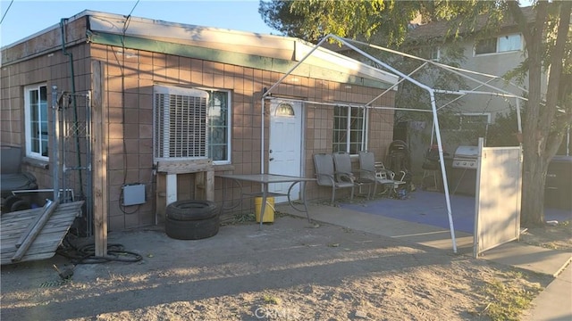 exterior space with glass enclosure and a patio area