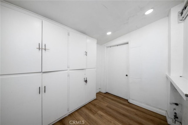 walk in closet with hardwood / wood-style floors and vaulted ceiling