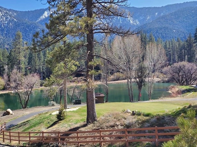 exterior space featuring a forest view, fence, and a mountain view