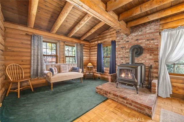sitting room with wood ceiling, rustic walls, a wood stove, and a wealth of natural light
