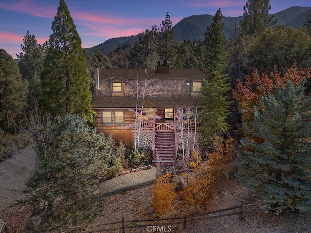 view of front of property with stairway, a chimney, and a mountain view