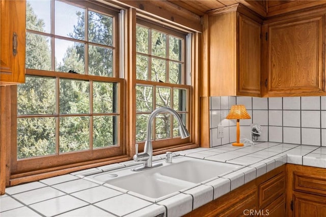 kitchen featuring tasteful backsplash, tile counters, and sink