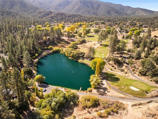 drone / aerial view with a water and mountain view and golf course view