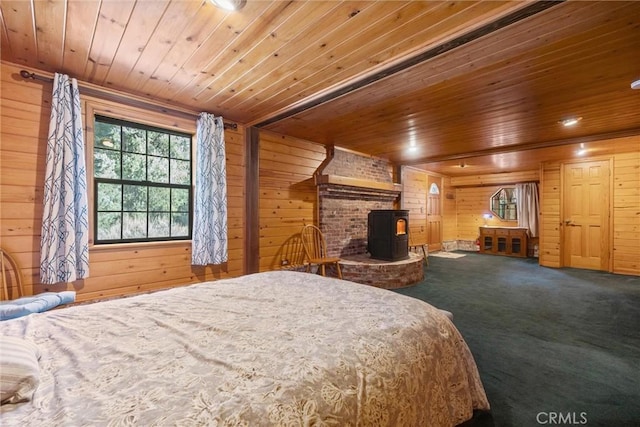 carpeted bedroom with a wood stove, wooden walls, and wooden ceiling