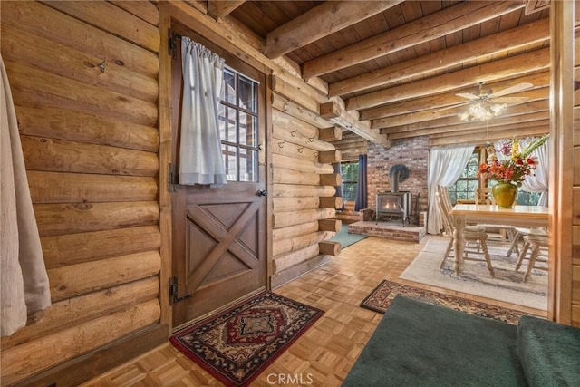 doorway to outside featuring beamed ceiling, a wood stove, rustic walls, and wood ceiling