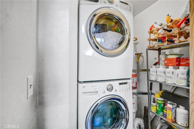 clothes washing area with stacked washer and clothes dryer