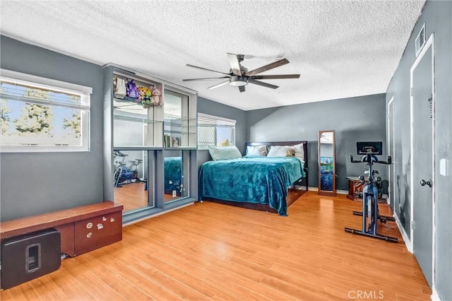 bedroom featuring ceiling fan, a textured ceiling, and hardwood / wood-style flooring