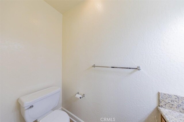 bathroom featuring vanity, lofted ceiling, and toilet