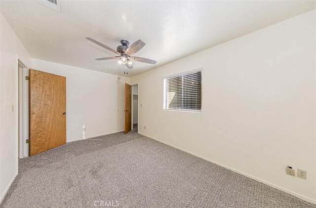 carpeted spare room featuring ceiling fan