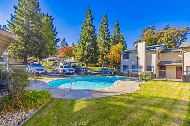 view of swimming pool with a yard and a patio