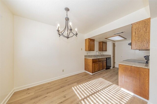 kitchen featuring black appliances, pendant lighting, sink, and light hardwood / wood-style floors