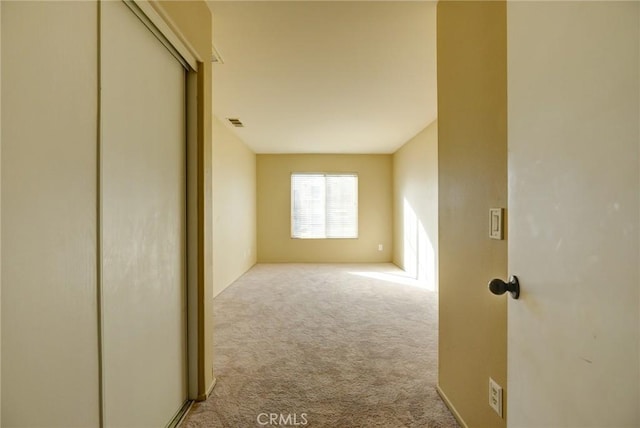 hallway featuring light colored carpet