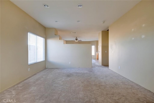 unfurnished room with ceiling fan and light carpet