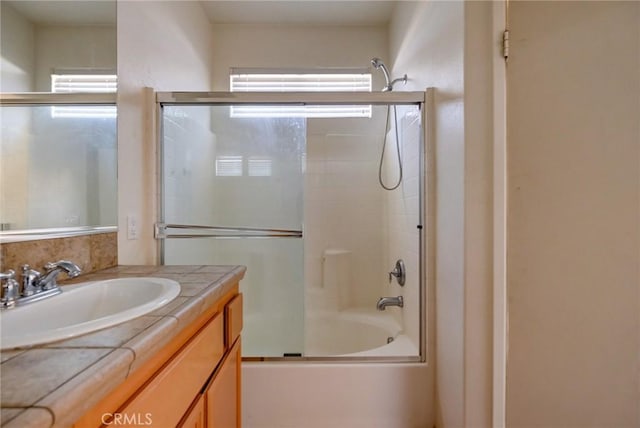 bathroom featuring vanity and shower / bath combination with glass door