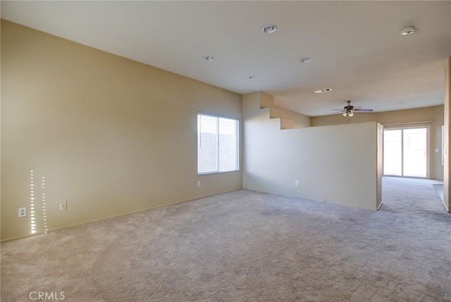 carpeted empty room with plenty of natural light and ceiling fan