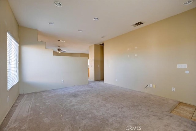 spare room with ceiling fan and light colored carpet