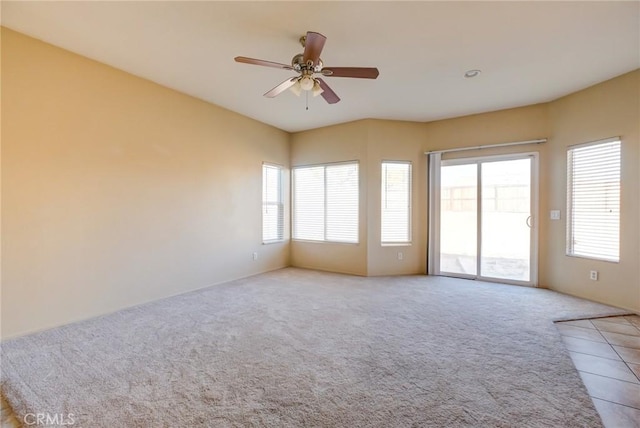 empty room featuring ceiling fan and light carpet