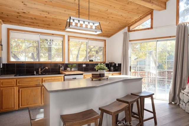 kitchen featuring dishwasher, lofted ceiling with beams, decorative light fixtures, light hardwood / wood-style floors, and wood ceiling