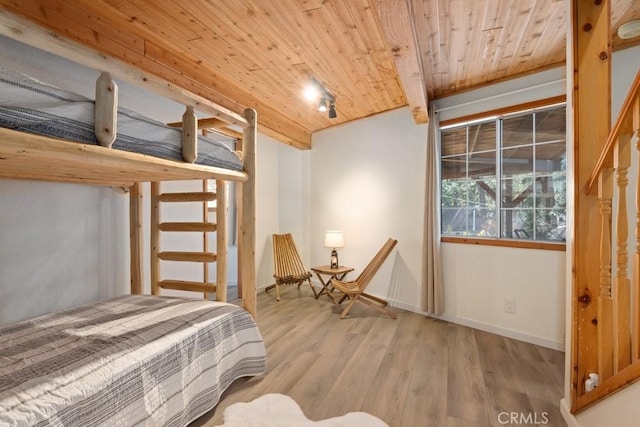 bedroom with wooden ceiling and light hardwood / wood-style flooring