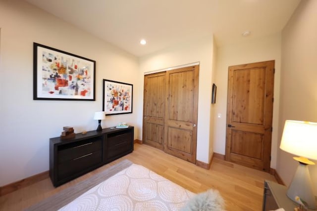 bedroom with light wood-type flooring and a closet