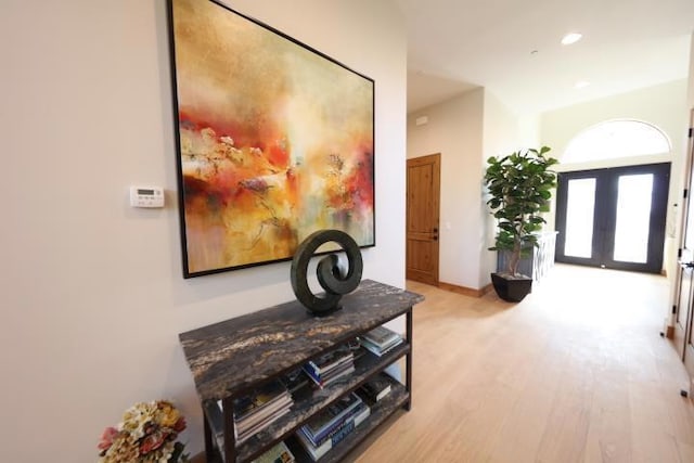 hall featuring light hardwood / wood-style floors and french doors