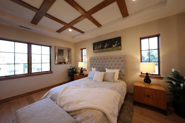 bedroom with hardwood / wood-style floors, coffered ceiling, beamed ceiling, and multiple windows