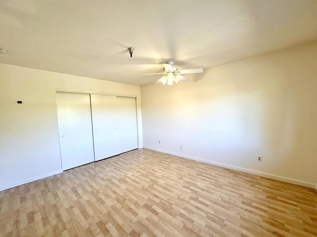 unfurnished bedroom featuring ceiling fan, light wood-type flooring, and a closet