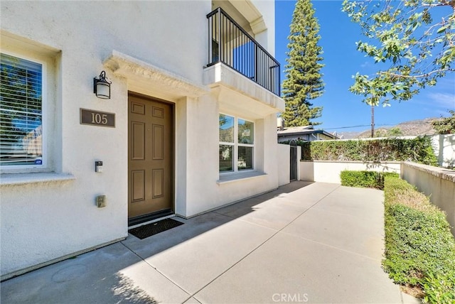 entrance to property featuring a balcony and a patio