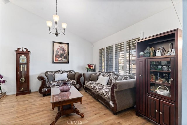 living room featuring light hardwood / wood-style floors, lofted ceiling, and a notable chandelier