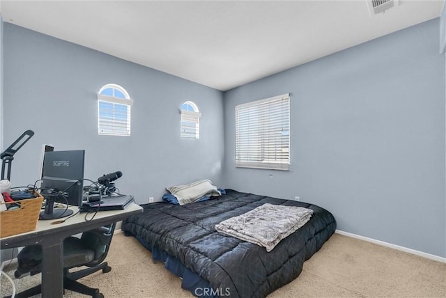 bedroom with light colored carpet and multiple windows