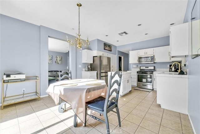 dining room with sink, light tile patterned flooring, and a chandelier