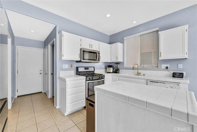 kitchen featuring tile counters, white cabinetry, and stainless steel appliances