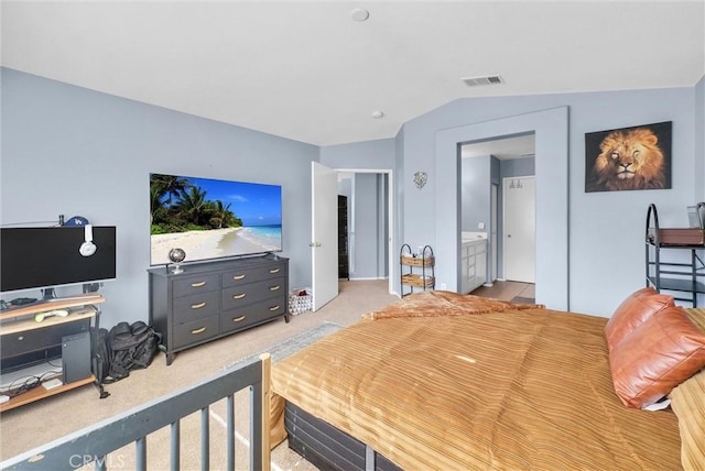 carpeted bedroom featuring ensuite bathroom and lofted ceiling