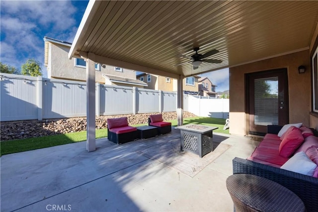 view of patio / terrace featuring ceiling fan and an outdoor living space with a fire pit