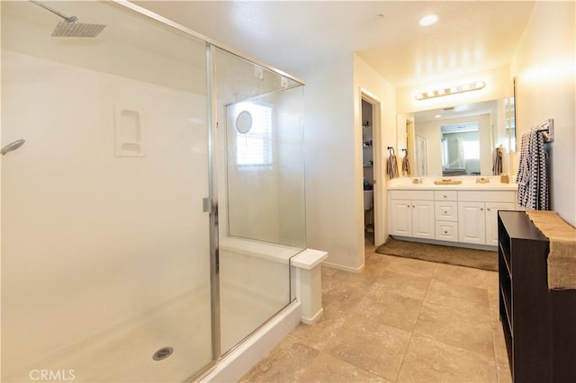 bathroom featuring vanity and a shower with door